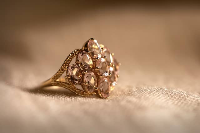 Gold cocktail ring with a cluster of pale pink oval stones and a rope-twist shank