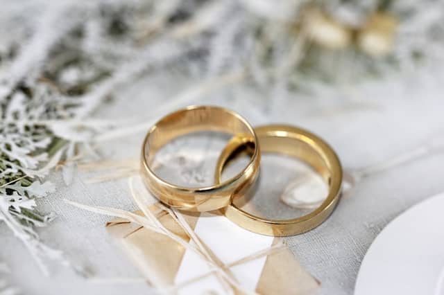 Two plain gold wedding bands resting together on a table